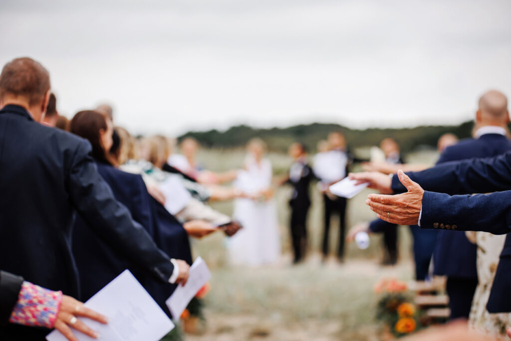 Bröllopsfotograf Skåne - Detaljbild under vigseln när alla gäster håller ut sina händer